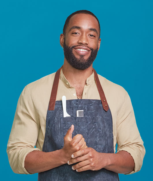 portrait of barber posing in front of a blue background