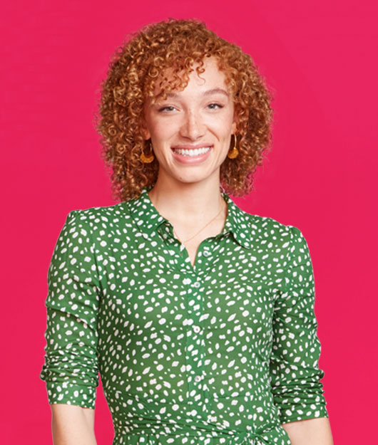 Portrait of woman smiling in front of a red background